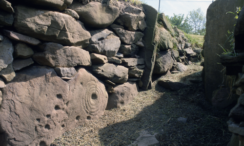 A photograph of a stone passage, with carvings on some of the stones