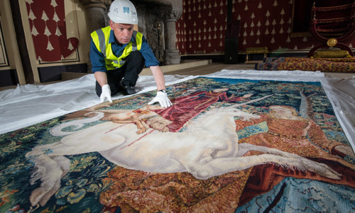 A member of staff working to care for one of the Unicorn Tapestries inside the palace at Stirling Castle.