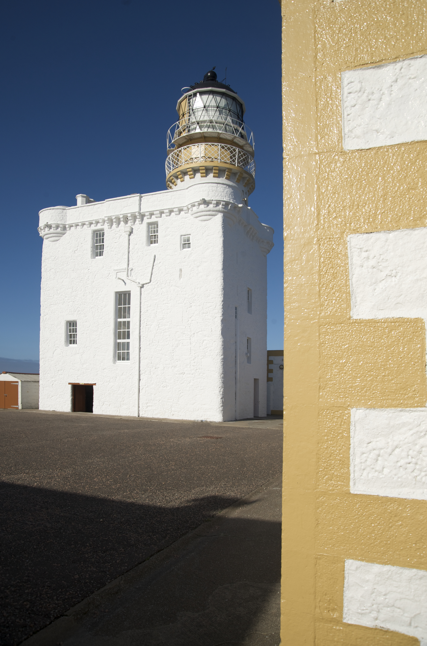 A whitewashed historic lighthouse building.