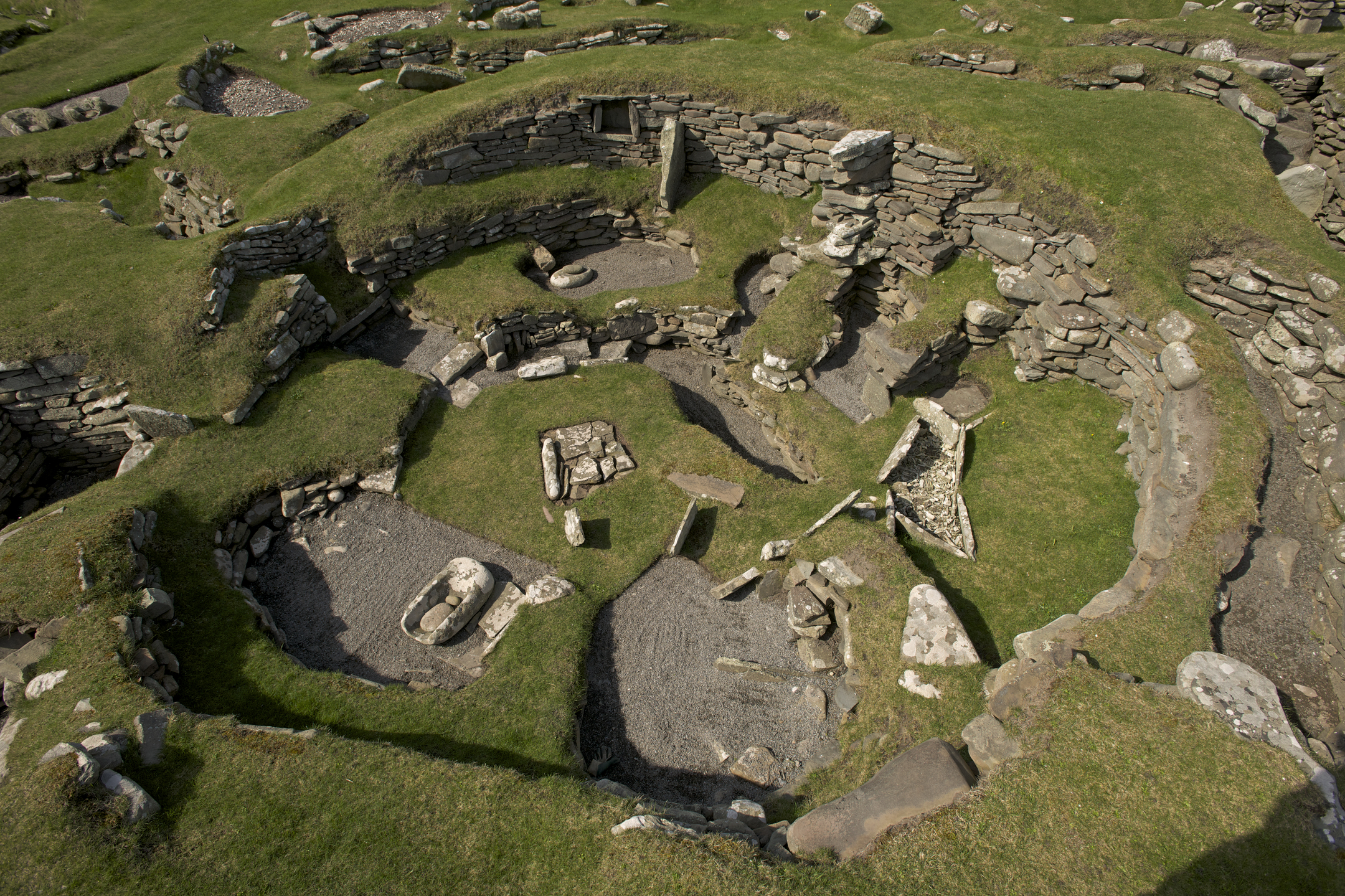 Aerial view looking down on grassy area with excavated building walls