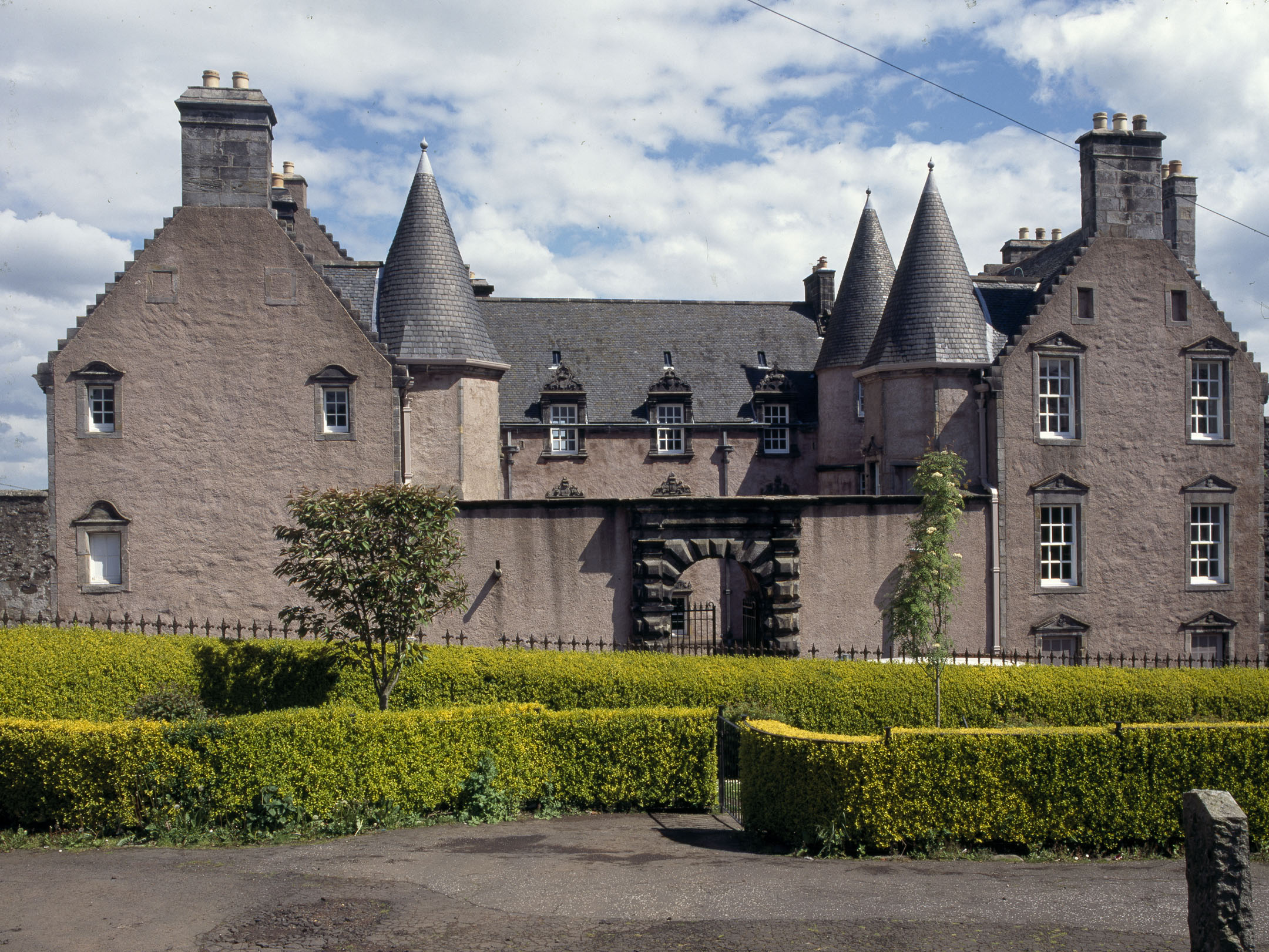 Exterior view of Argyll's Lodging with turrets and hedge in foreground.