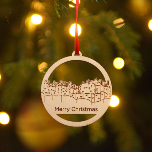 Wooden Christmas tree ornament with a castle carved in and the words Merry Christmas