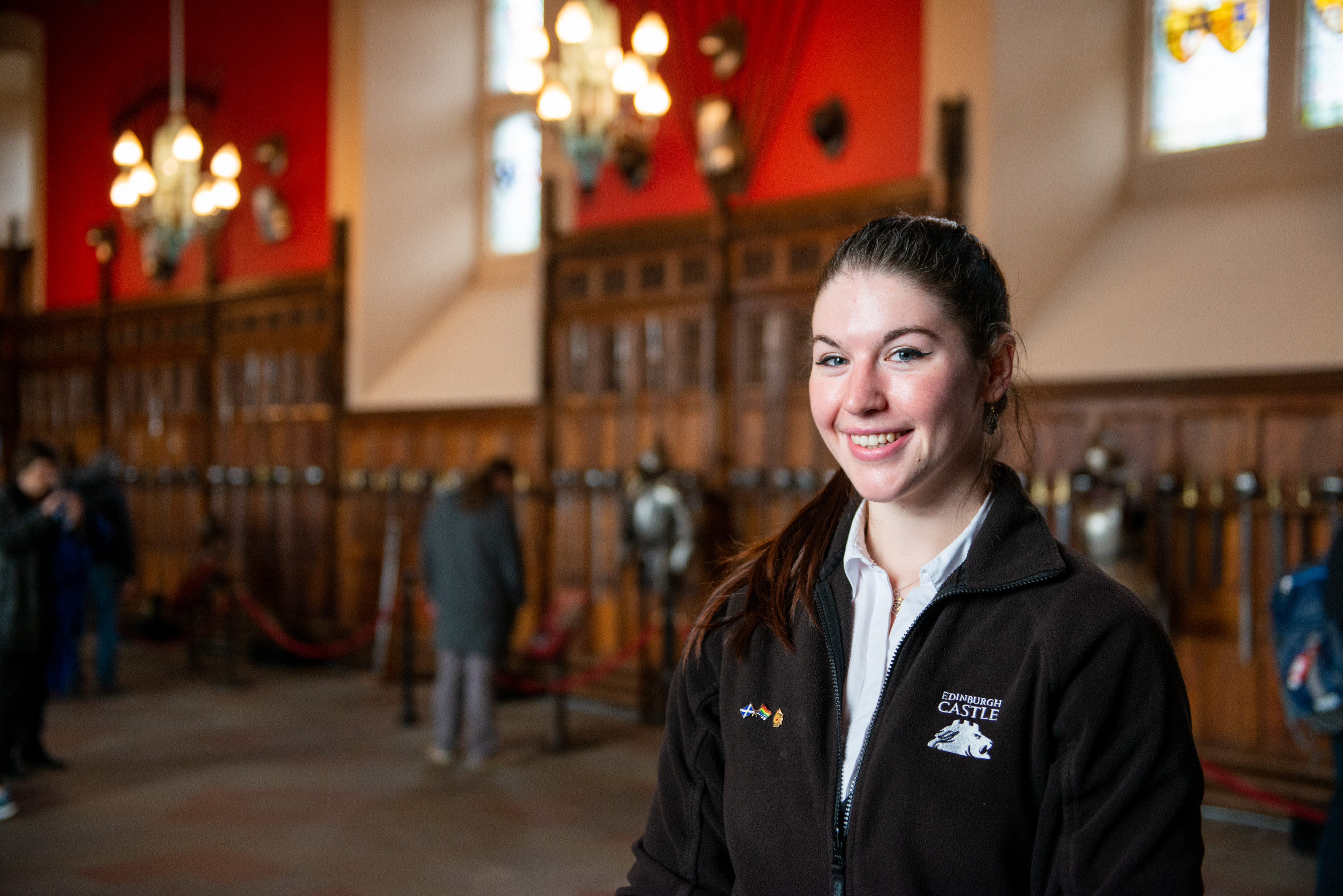 A friendly staff member in an Edinburgh Castle fleece inside the great hall