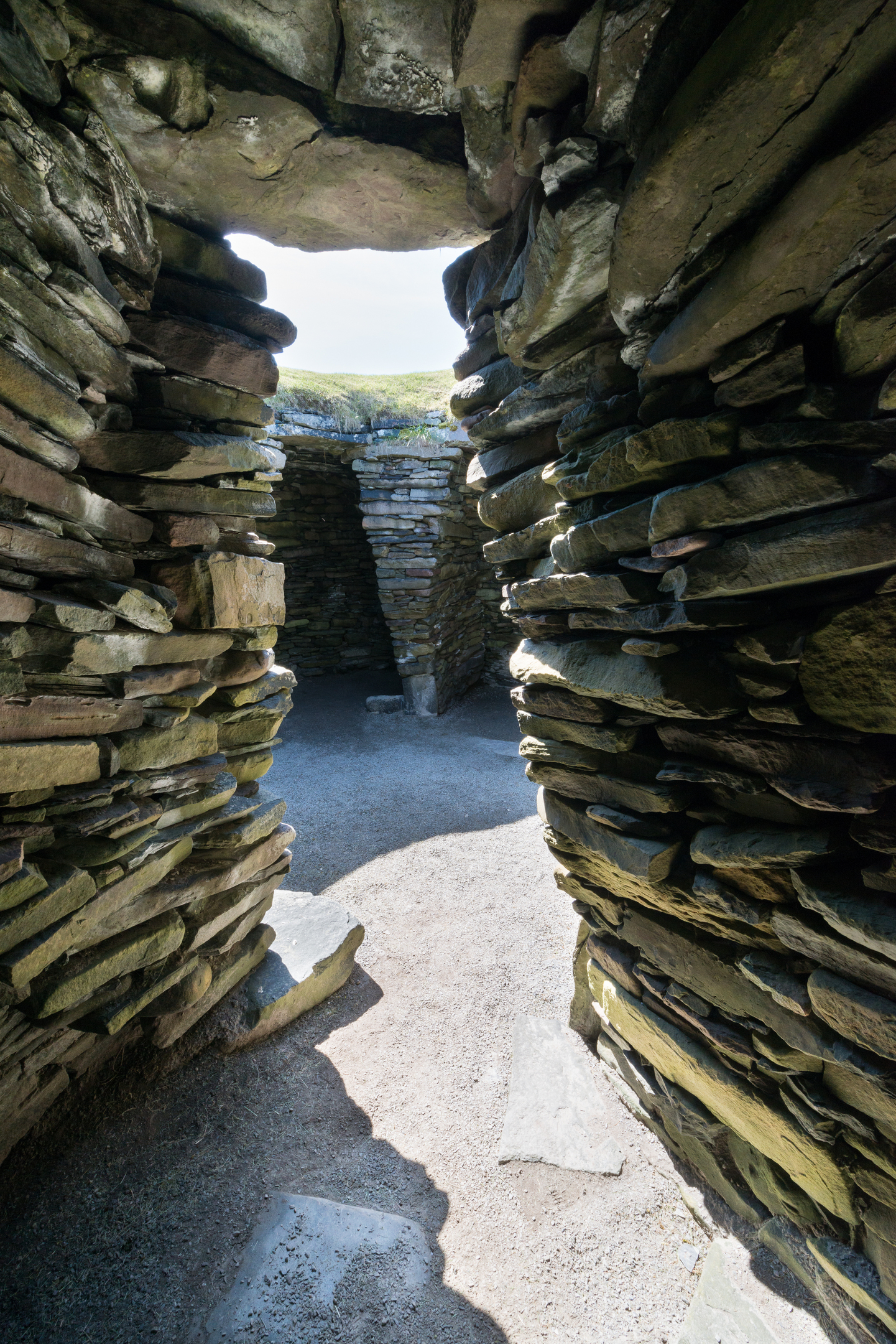 View through narrow pathway between loose stone walls