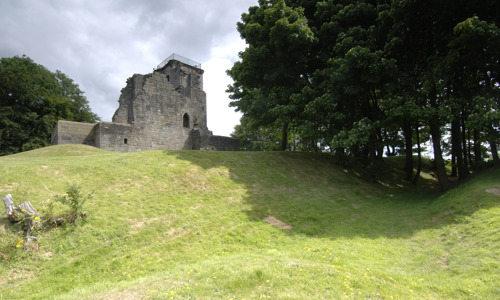 A square stone tower house in remarkable condition seen from below