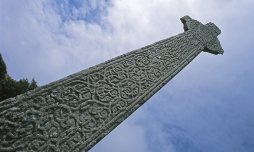 A intricately carved celtic stone reaching up into the sky