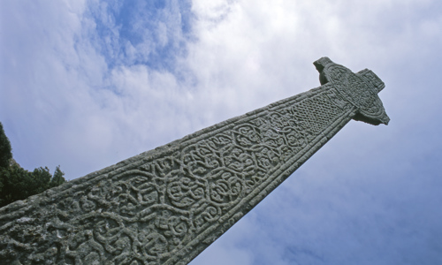 A intricately carved celtic stone reaching up into the sky