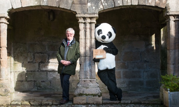 Chief executive David Middleton poses with a person dressed as a panda at Castle Campbell with a certificate from the World Wildlife Fund.