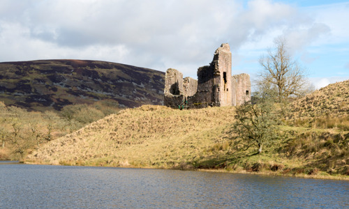 Majestically situated on a promontory overlooking Morton Loch sit the ruins of Morton Castle on a sunny day