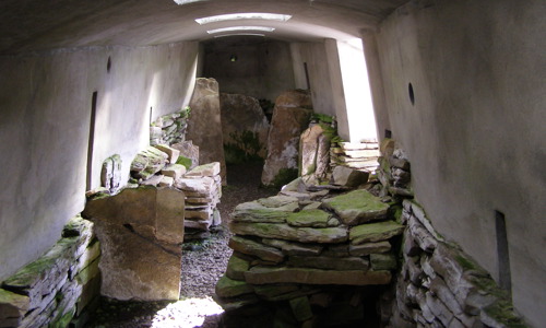 Several slabs of stone being stored in a concrete room