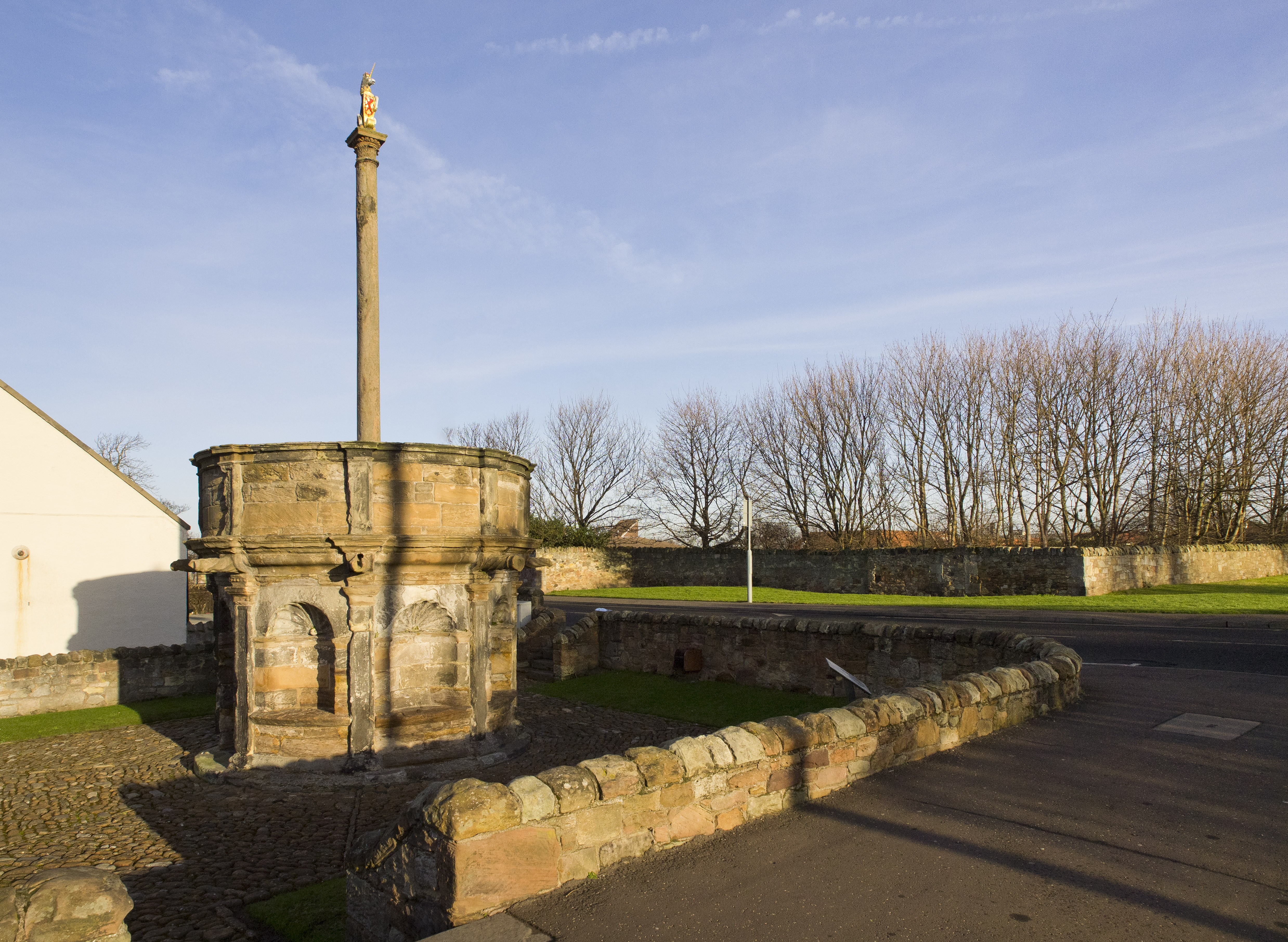 A tall cross on top of a large cylindrical base