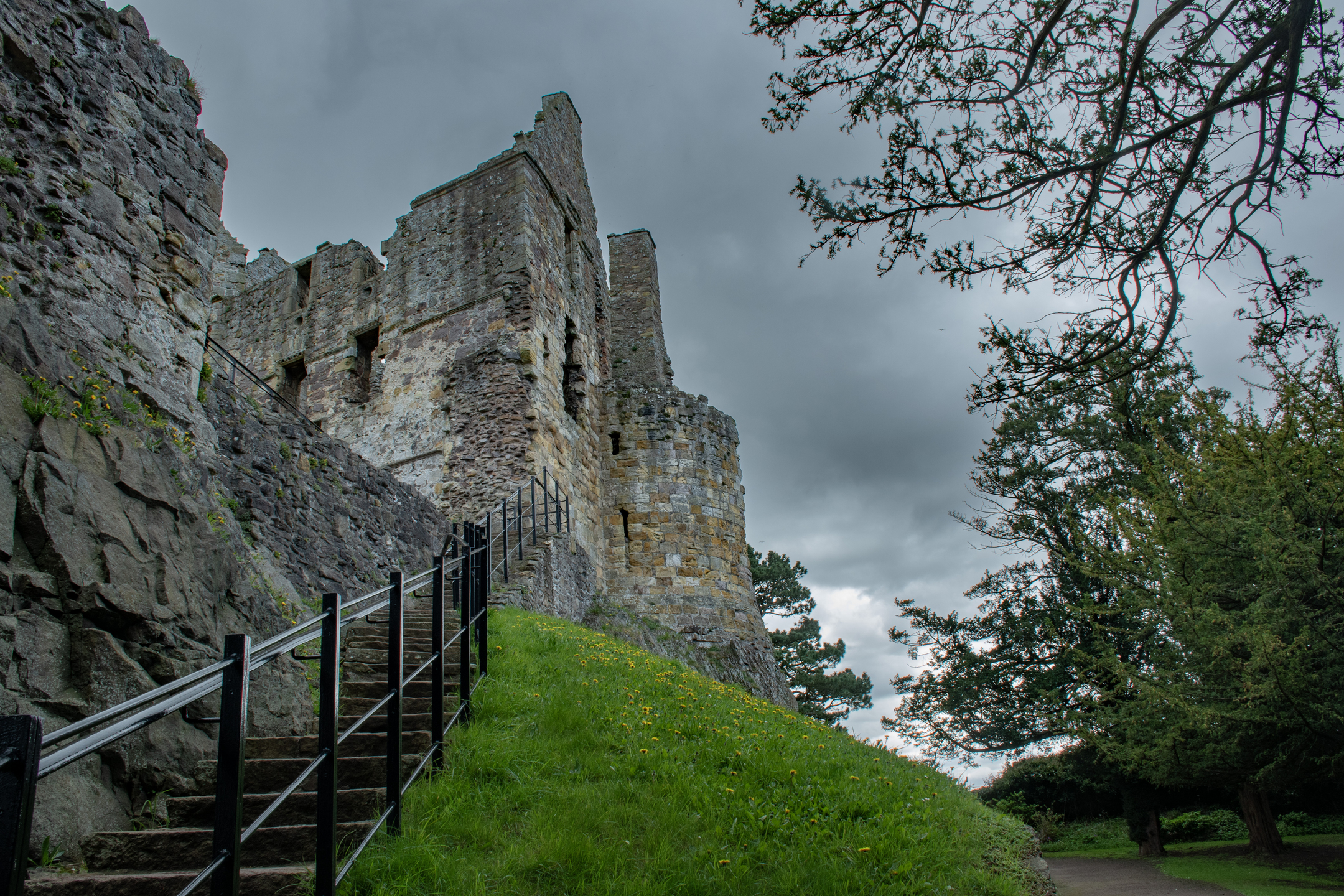 A stairway leads from bottom left to the centre, upwards to the base of a castle ruin with a moody sky
