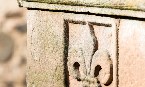 A detail of a Fleur-de-Lys carved into an oriel window at Huntly Castle.