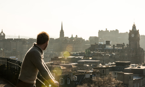 Man admiring the view of Edinburgh from Calton Hill in the sunshine