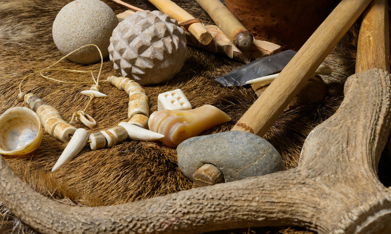 A collection of replica neolithic objects including an antler pick