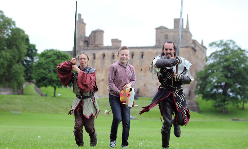 Two re-enactors with swords and a boy at Linlithgow Palace