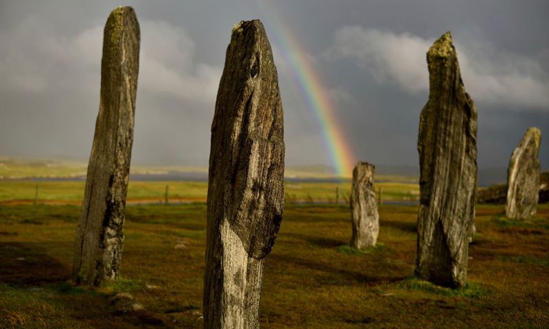 The Calanais Standing Stones with a rainbow in the background