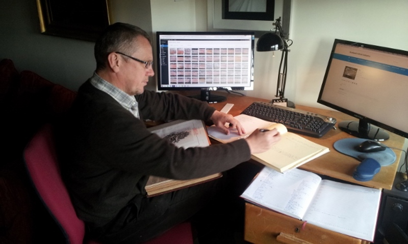 A man working at a desk with books and monitors