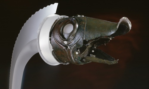 Head of a Carnyx with dark red background