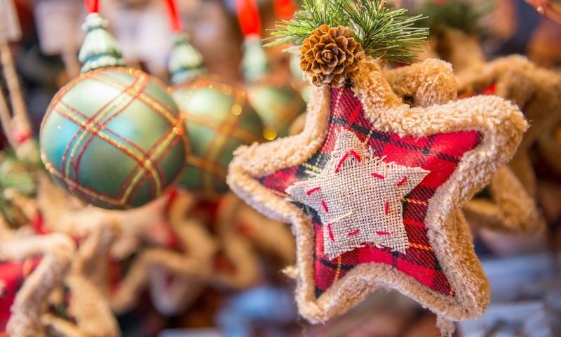 A bauble and star Christmas tree decorations next to a mirror