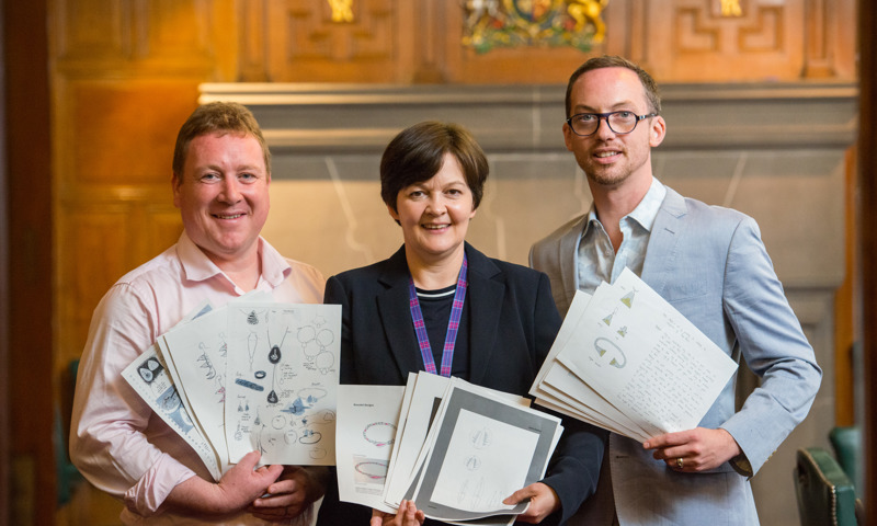 Three awards judges holding pieces of paper