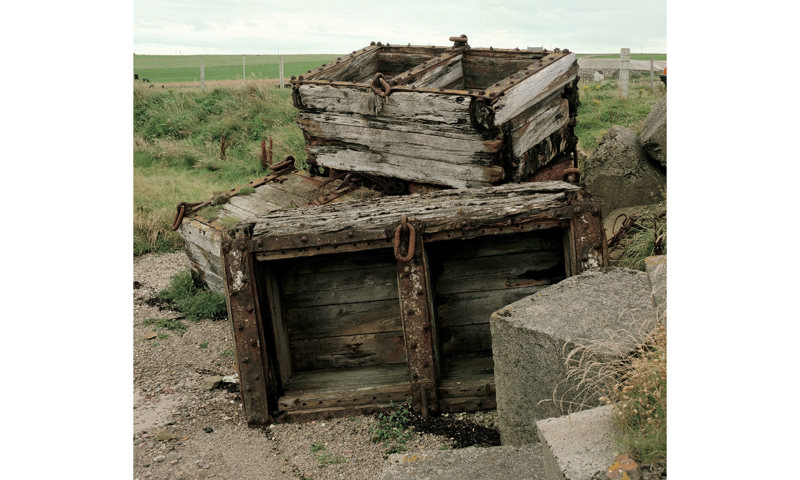 Pile of old wooden crates with metal brackets and hinges