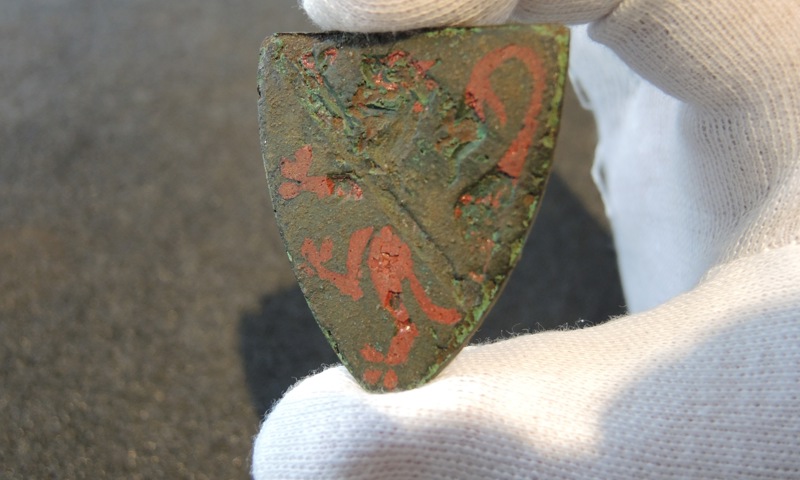 An arrowhead decorated with a red lion