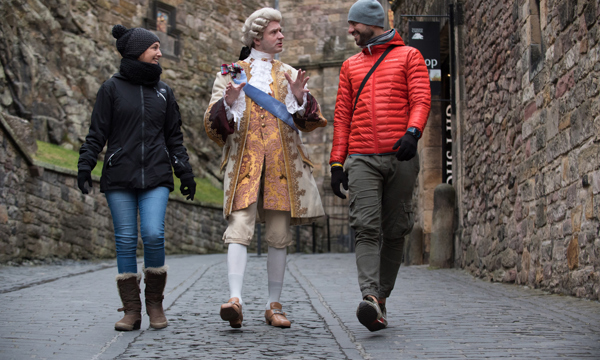 Mark Kydd, dressed as Bonnie Prince Charlie, talking with tourists at Edinburgh Castle