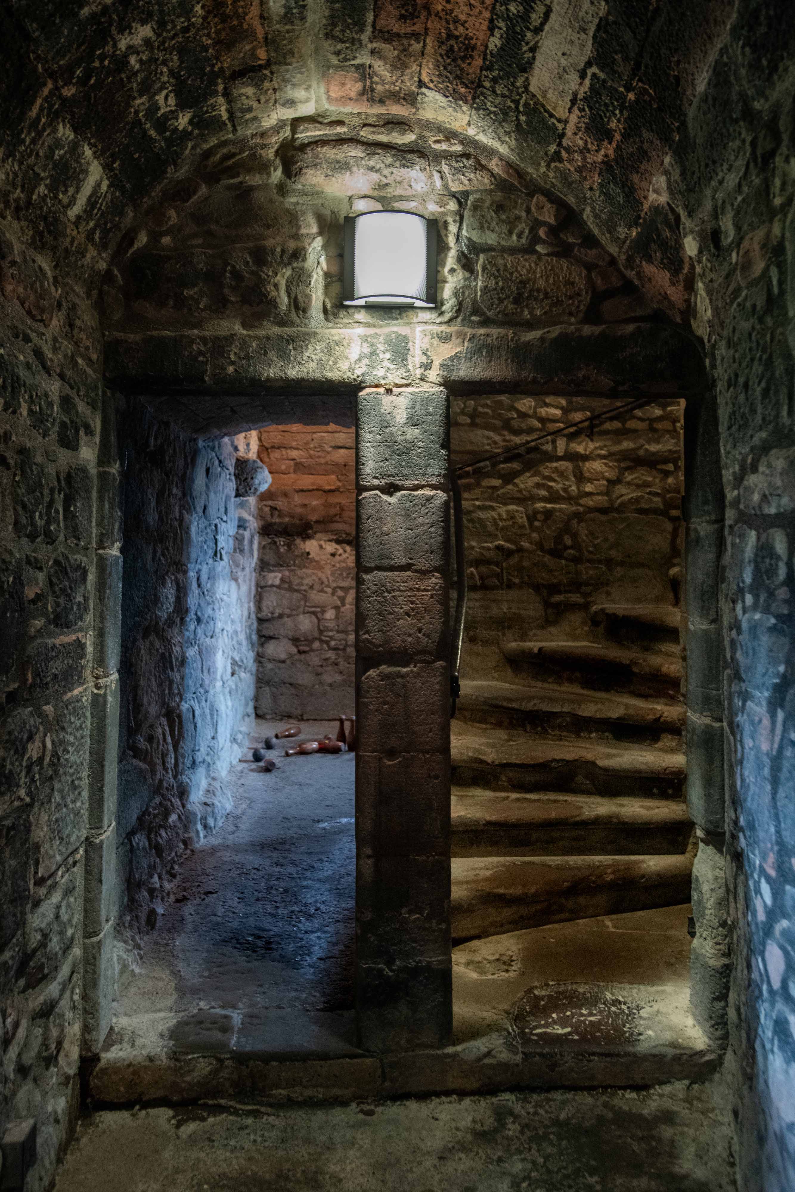 A doorway beside a curved staircase inside a stone castle