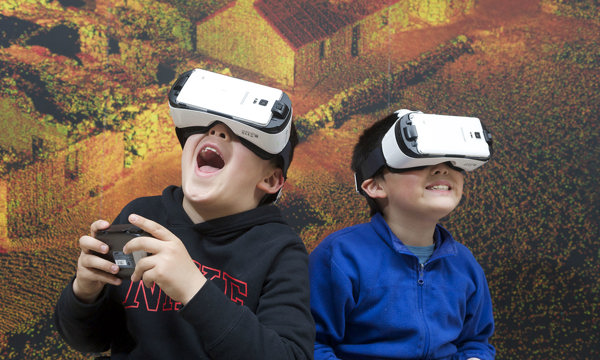 Children having fun using VR headsets