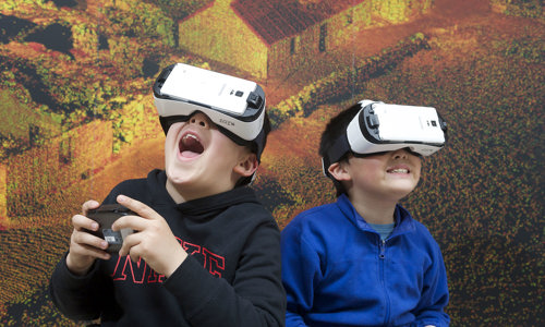 Children having fun using VR headsets