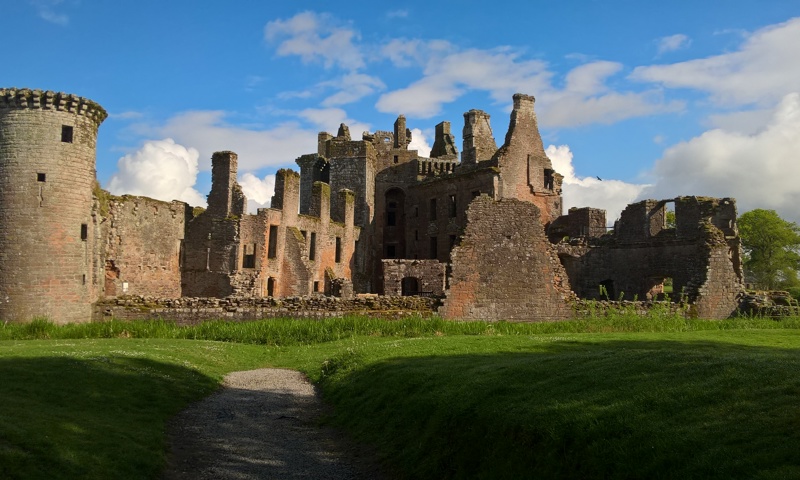 Exterior view of Caerlaverock Castle on a sunny day with a little white cloud