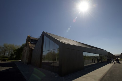 Exterior shot of the Engine Shed with clear sky and sun in the background