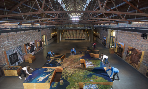 People moving a large-scale map of Scotland compiled from hi-resolution satellite images into place