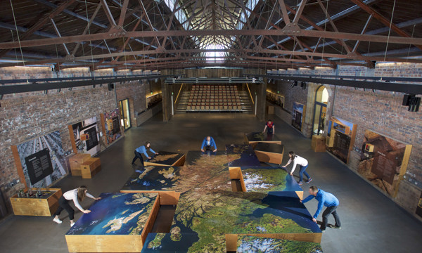 People moving a large-scale map of Scotland compiled from hi-resolution satellite images into place