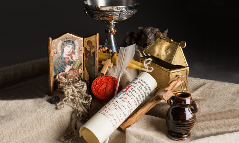 Arrangement of relics including parchment, a chalice, a quill and other items