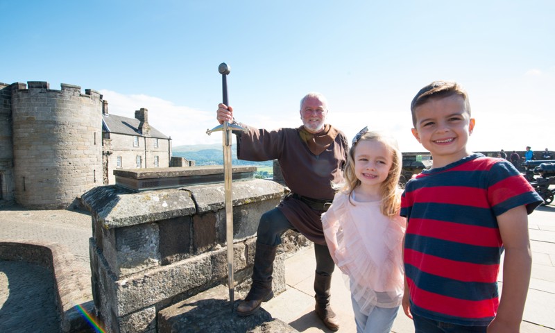 Costumed performer with a sword and children at Stirling Castle