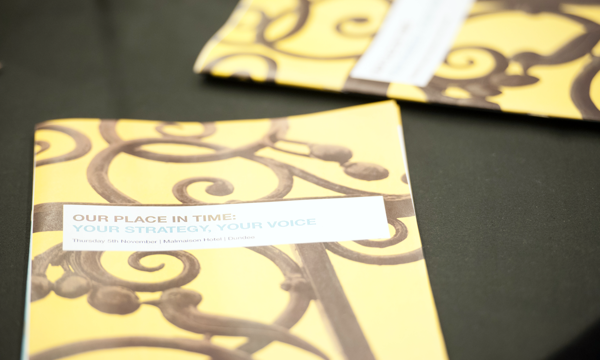 A photograph of two books with yellow covers and an ironwork design.