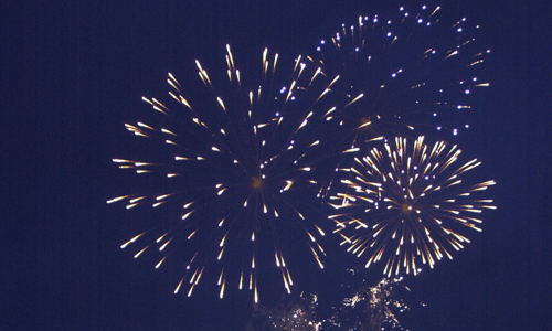 orange and yellow fireworks against a dark blue sky 