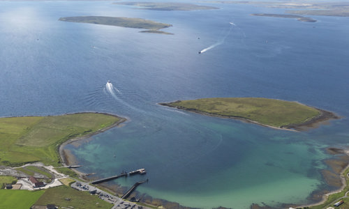 a bay of blue water with green land curving around it