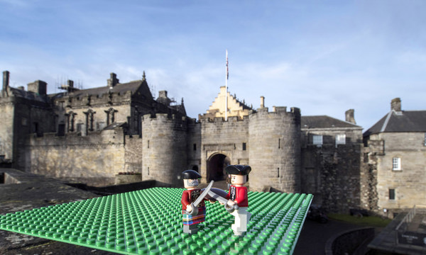 lego soldiers duel with a castle in the background