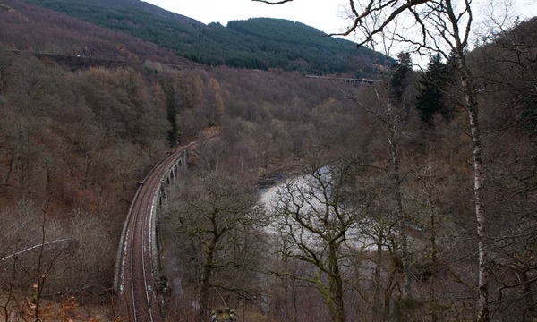A photograph of a landscape with a railway bridge running through it.