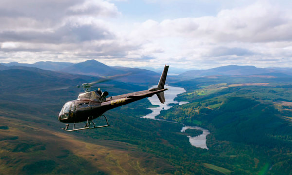 A photograph of a helicopter over hills.