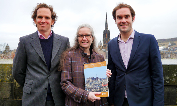 three people in a row with a city skyline behind them