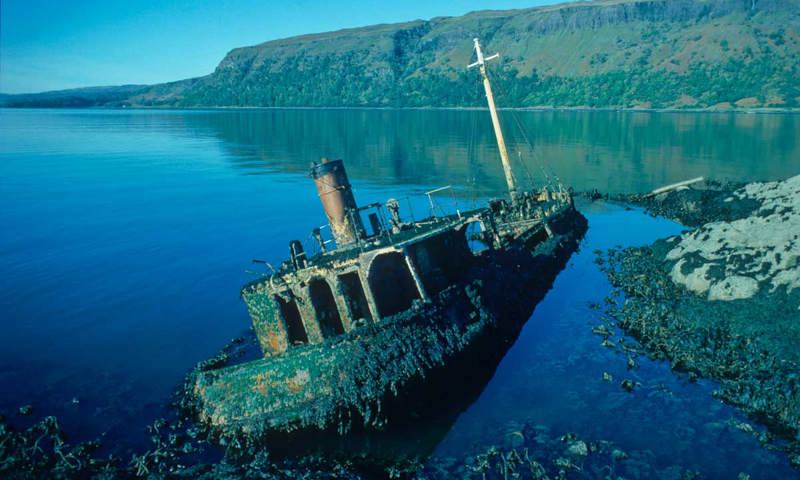 A wrecked boat half in the water