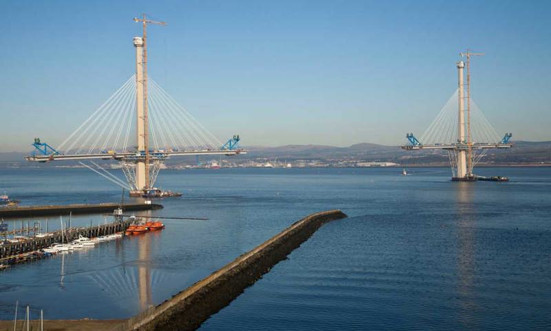 A photograph of a bridge under construction on a sunny day.