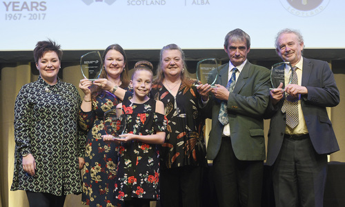 Group of winners accepting award on stage