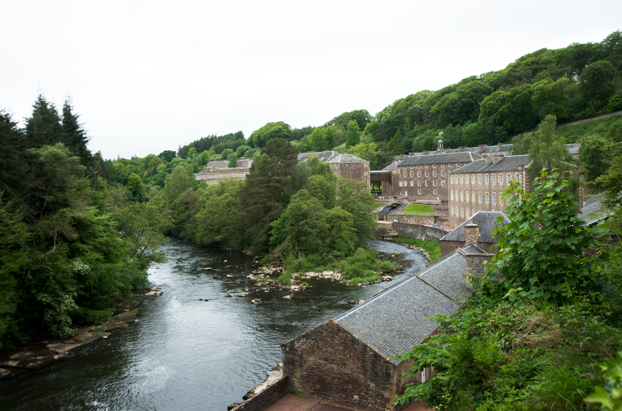 18th century stone mill buildings on the edge of the river Clyde