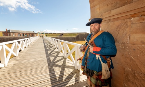A man dressed as a Jacobite stands at the entry to Fort George