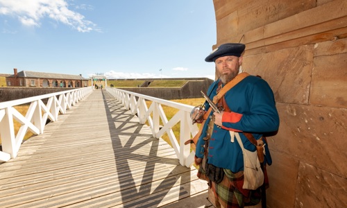 A man dressed as a Jacobite stands at the entry to Fort George